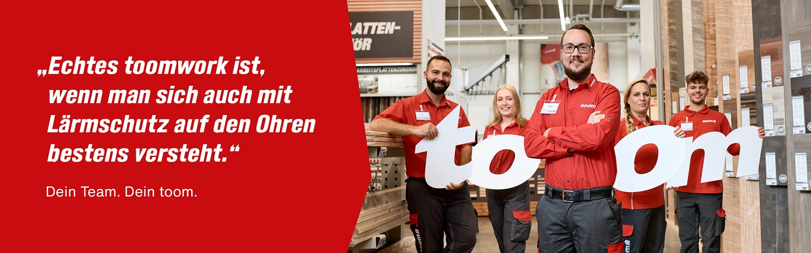In einem Baumarkt stehen fünf Mitarbeitende und halten die Buchstaben des Wortes toom in den Händen